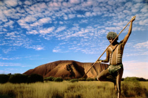 Aboriginal hunter in outback at sunset.