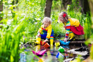 children-play-with-colorful-paper-boats-in-a-small-river-on-a-sunny-spring-day-kids-playing
